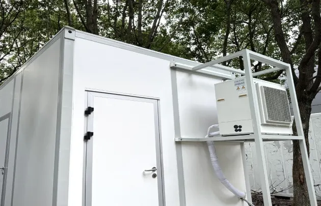 Exterior of a container laboratory module with cleanroom door and dedicated HVAC condenser platform