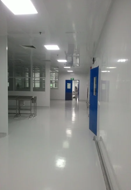 Pharmaceutical cleanroom corridor with flush wall panels and cleanable ceiling joints