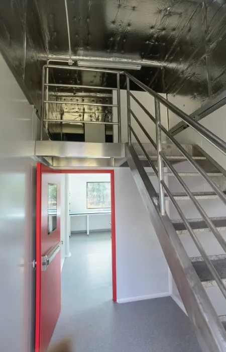 Containerized pharma cleanroom service mezzanine separating maintenance route from clean area