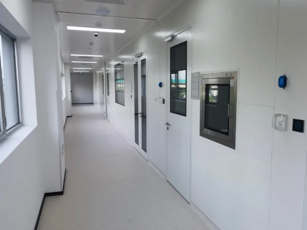 Wonclean real project photo of a cleanroom corridor with wall panels, access doors, pass box and ceiling service points
