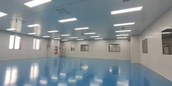 Illustrative empty cleanroom interior with sealed wall finishes, lighting and a blue floor