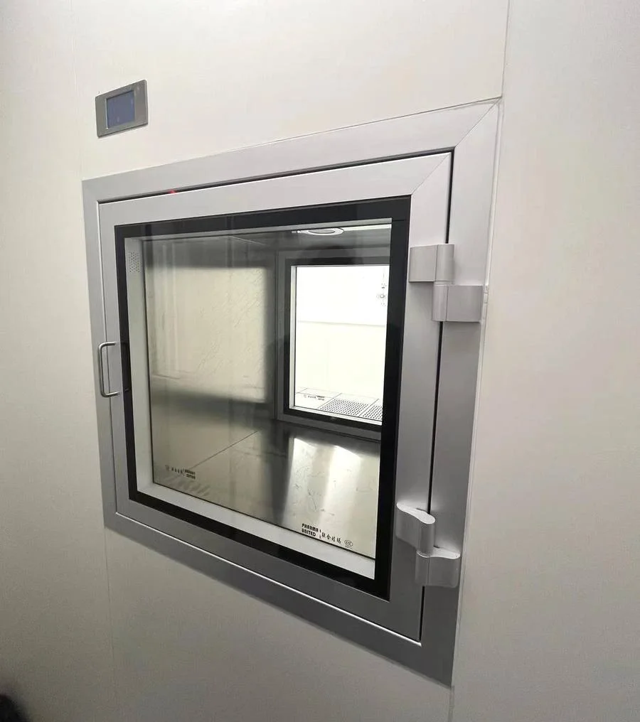 Stainless-steel interlocked cleanroom pass box set into a flush wall panel, used to transfer materials into a clean zone without breaking the pressure cascade